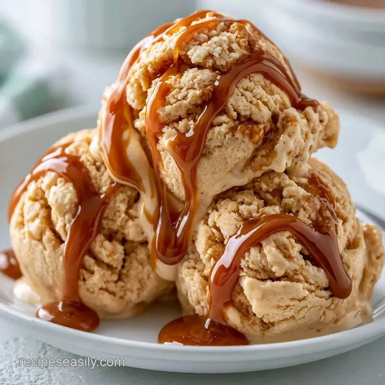 Three neat scoops of ivory white frozen dessert in a glass coupe, topped with a pinch of warm cinnamon powder.